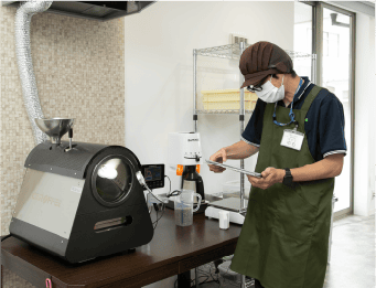 神戸市須磨区焙煎コーヒーの就労支援 step2.焙煎機でコーヒー豆の焙煎を職員が見守っている