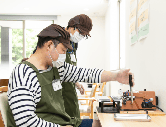 神戸市須磨区焙煎コーヒーの就労支援 step4.焙煎の澄んだコーヒー豆をオリジナルデザインのパッケージに手作業で詰めている様子